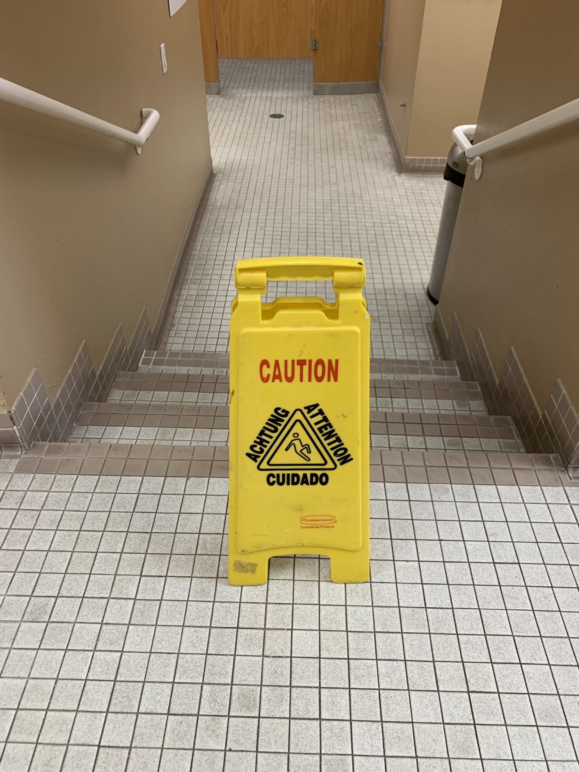 Slippery when wet floor sign on small tiles with lots of grout lines