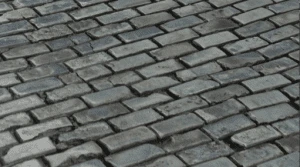 uneven weathered cobblestone pavement with rectangular stones