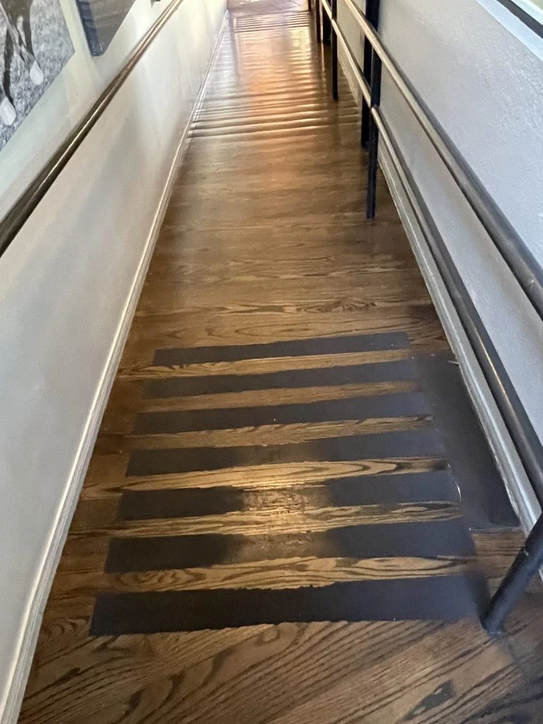 hallway with striped floor and metal railings